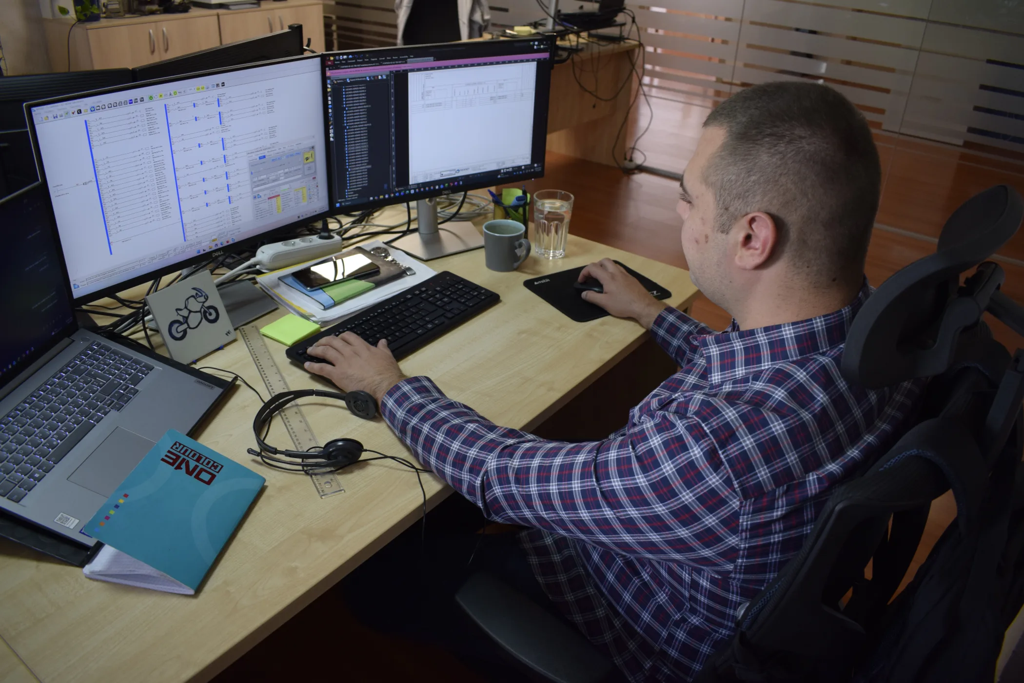 Engineer at a workstation with several monitors
